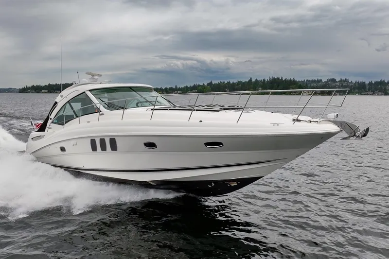 Slide: The Image of 2010 Sea Ray 500 Sundancer cruising on a lake under cloudy skies. - 7