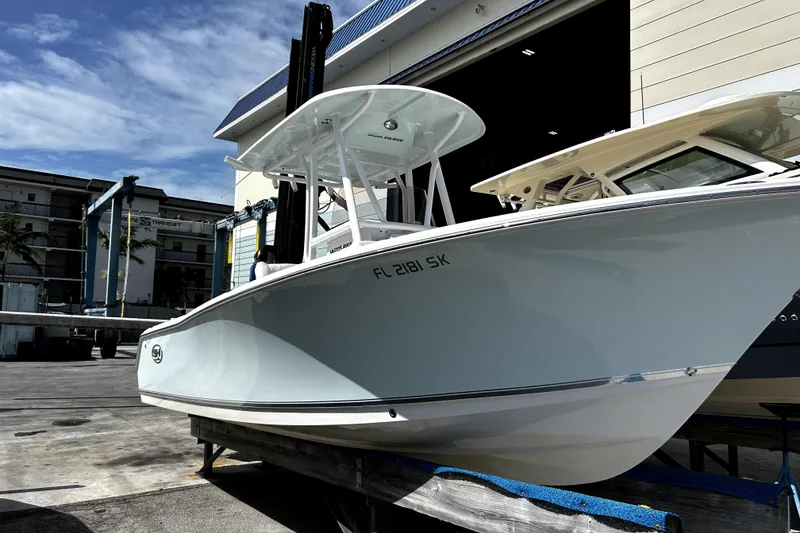 Slide: The Image of 2017 Sea Hunt Ultra 232 boat docked at a marina under a clear blue sky. - 12