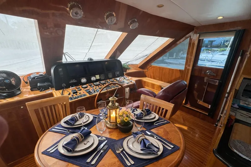 Slide: The Image of Luxurious 2003 Altima 55 Pilothouse interior with elegant dining setup and navigation controls. - 31