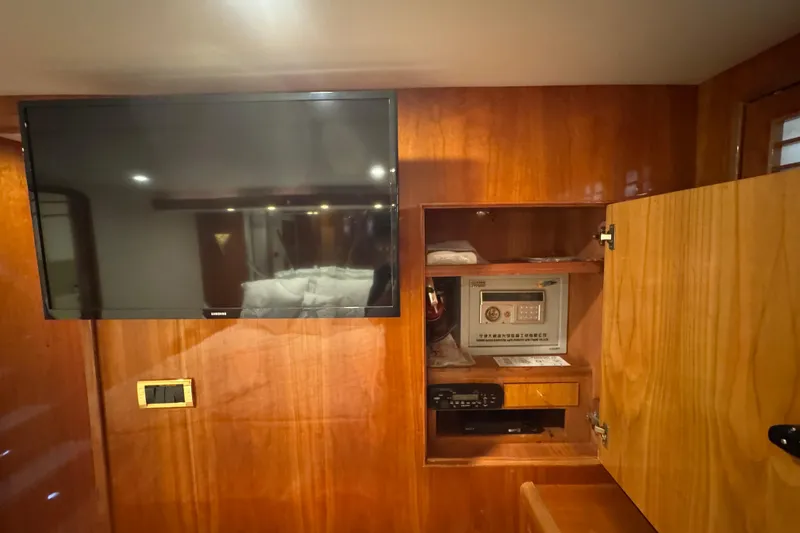 Slide: The Image of Interior of 2003 Altima 55 Pilothouse with TV and open cabinet revealing safe. - 45
