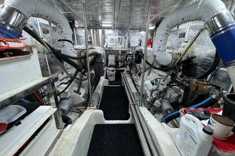 Slide: The Image of Engine room of 2003 Altima 55 Pilothouse yacht, featuring dual engines and mechanical components. - 54