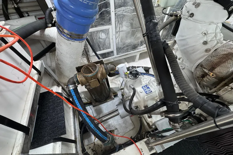 Slide: The Image of Engine room of 2003 Altima 55 Pilothouse with visible mechanical components and hoses. - 63