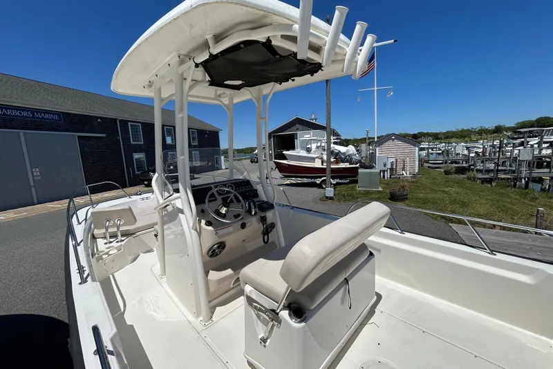 Slide: The Image of 2021 Boston Whaler 210 Montauk boat at a marina, showcasing helm and seating area. - 10