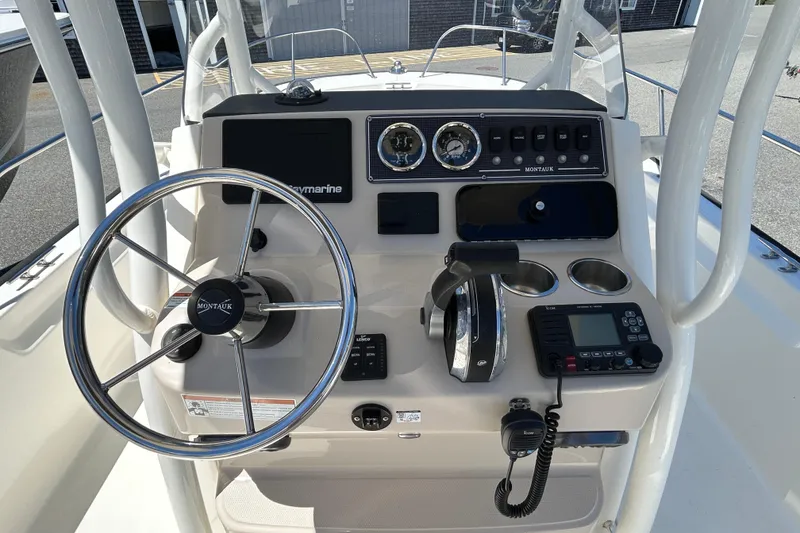 Slide: The Image of 2021 Boston Whaler 210 Montauk boat dashboard with steering wheel and controls. - 13