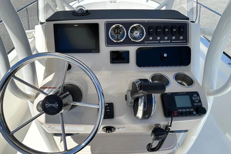 Slide: The Image of Control panel of a 2021 Boston Whaler 210 Montauk boat with steering wheel and gauges. - 14