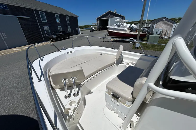 Slide: The Image of 2021 Boston Whaler 210 Montauk boat interior with seating and storage, docked at a marina. - 15