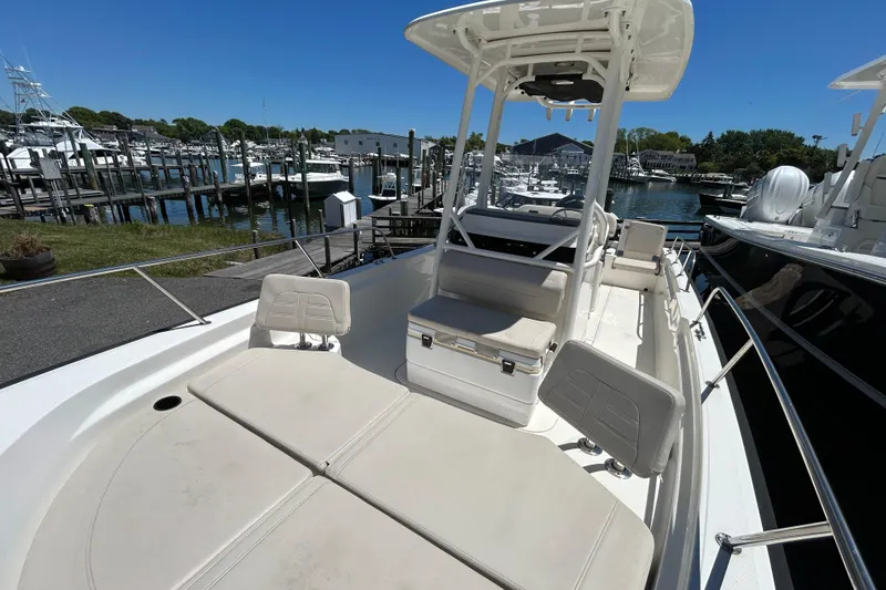Slide: The Image of 2021 Boston Whaler 210 Montauk boat docked at a marina under clear blue skies. - 17