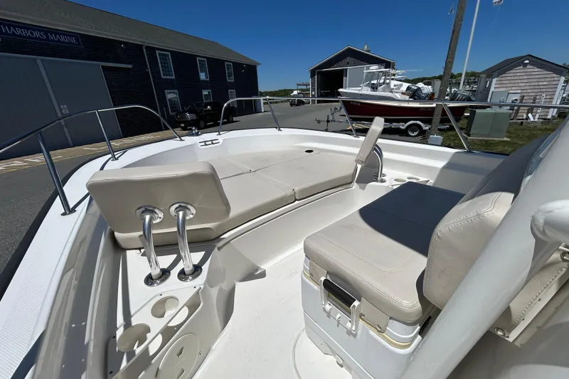 Slide: The Image of 2021 Boston Whaler 210 Montauk boat interior with seating and storage, docked at a marina. - 20