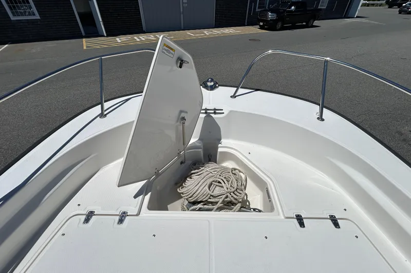 Slide: The Image of 2021 Boston Whaler 210 Montauk boat with open storage compartment and coiled rope. - 24