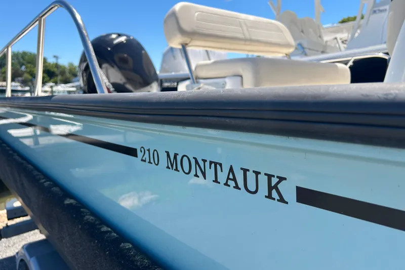 Slide: The Image of 2021 Boston Whaler 210 Montauk boat side view with clear branding. - 26