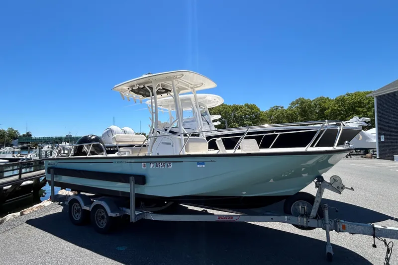 Slide: The Image of 2021 Boston Whaler 210 Montauk boat on trailer at marina under clear blue sky. - 3