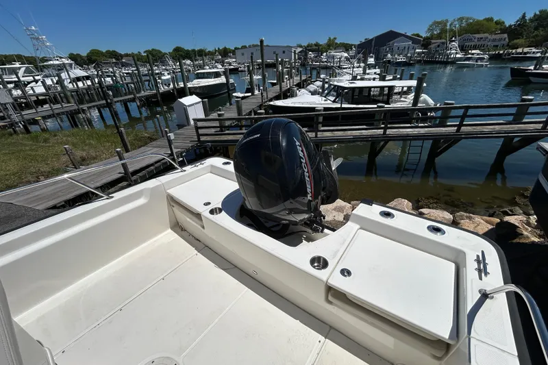 Slide: The Image of 2021 Boston Whaler 210 Montauk boat docked at a marina with Mercury outboard motor. - 7