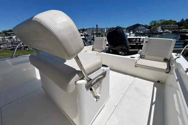 Slide: The Image of 2021 Boston Whaler 210 Montauk boat interior with seating and motor, docked at marina. - 9