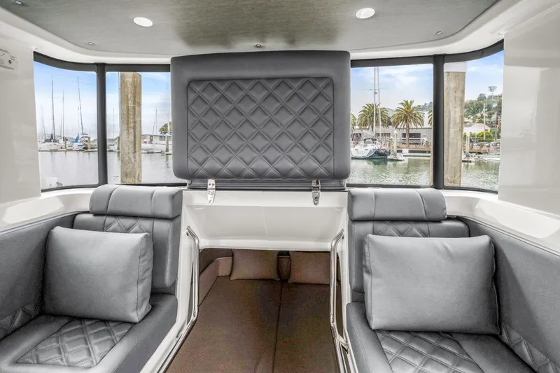 Slide: The Image of Luxurious interior of 2021 Axopar 37 XC Cross Cabin with quilted seating and marina view. - 18