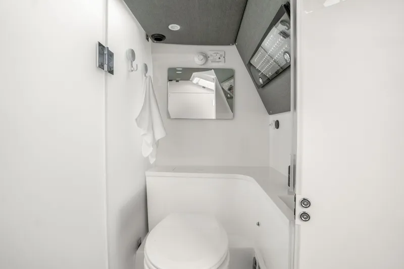 Slide: The Image of 2021 Axopar 37 XC Cross Cabin bathroom interior with modern fixtures and mirror. - 23