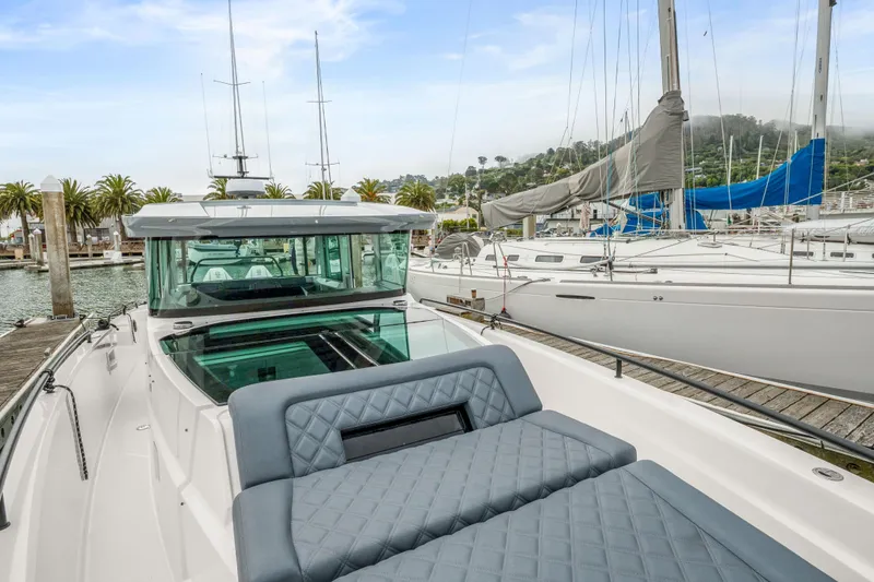 Slide: The Image of 2021 Axopar 37 XC Cross Cabin docked at marina with sailboats. - 33