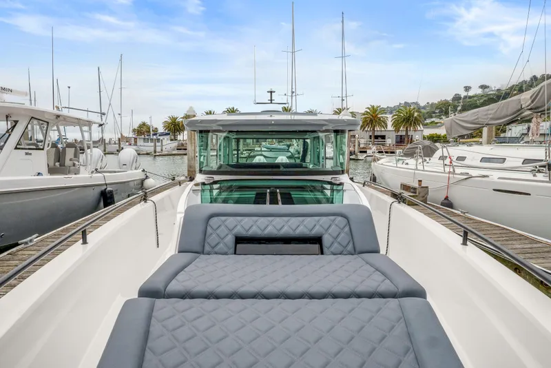Slide: The Image of 2021 Axopar 37 XC Cross Cabin boat docked in a marina with palm trees. - 34