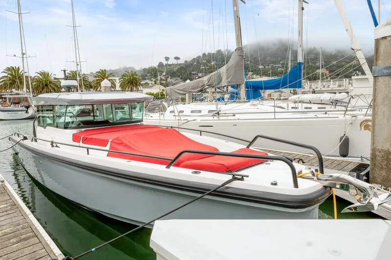 Slide: The Image of 2021 Axopar 37 XC Cross Cabin docked at a marina with sailboats. - 45