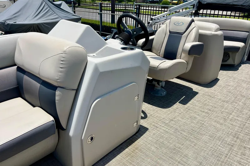 Slide: The Image of 2023 Harris Cruiser 230 boat interior with steering console and plush seating. - 11
