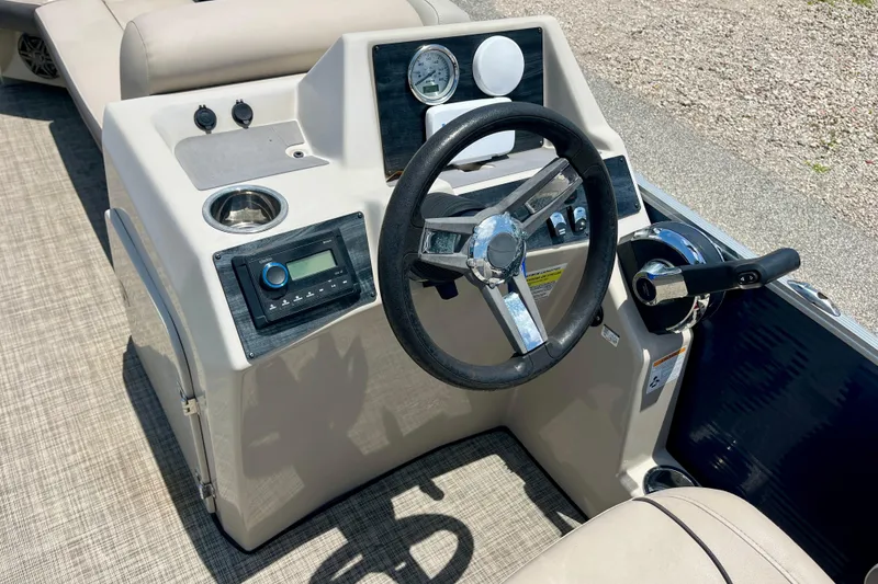 Slide: The Image of 2023 Harris Cruiser 230 boat dashboard with steering wheel and controls. - 12