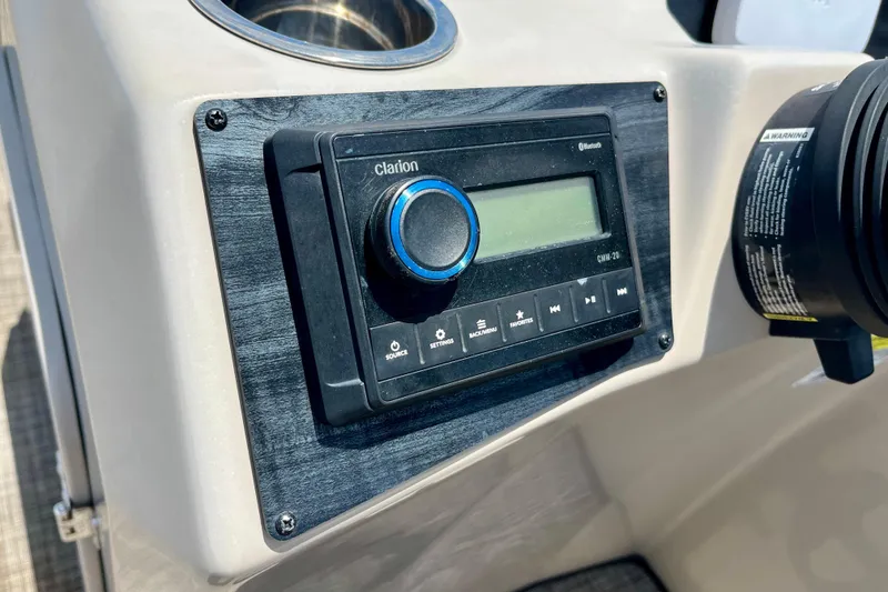 Slide: The Image of 2023 Harris Cruiser 230 dashboard featuring a Clarion audio system with Bluetooth connectivity. - 13