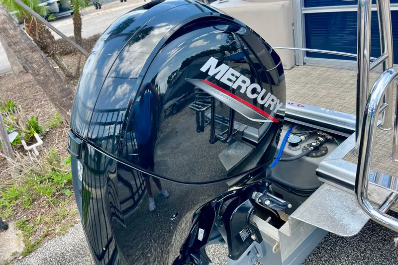 Slide: The Image of 2023 Harris Cruiser 230 with Mercury outboard motor, docked on a sunny day. - 6