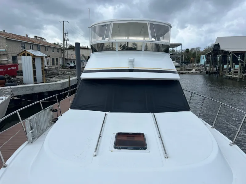Slide: The Image of 1998 Hyatt 51 Aft Cabin Motor Yacht docked, showcasing sleek design and spacious deck. - 17