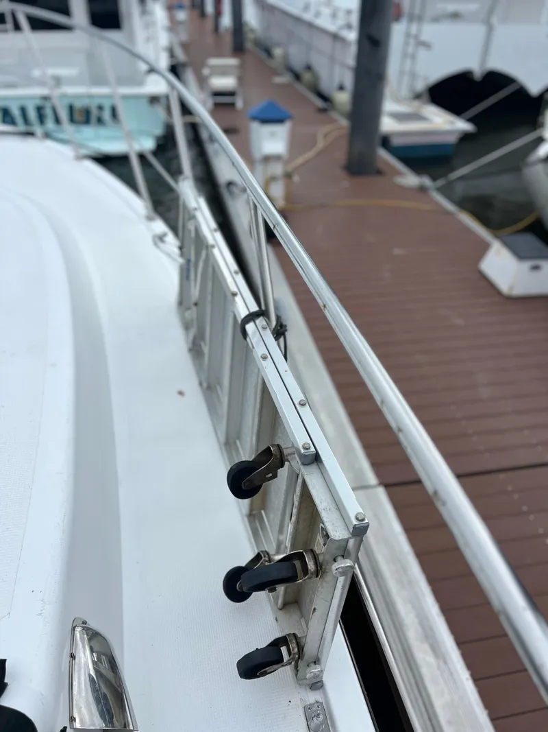 Slide: The Image of 1998 Hyatt 51 Aft Cabin Motor Yacht docked, showcasing railing and deck details. - 22
