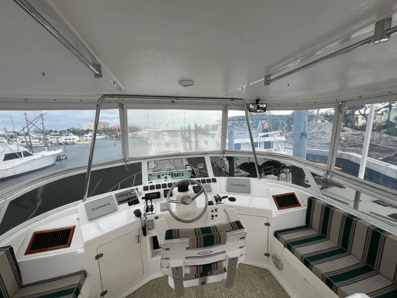 Slide: The Image of 1998 Hyatt 51 Aft Cabin Motor Yacht helm with striped seating and marina view. - 38