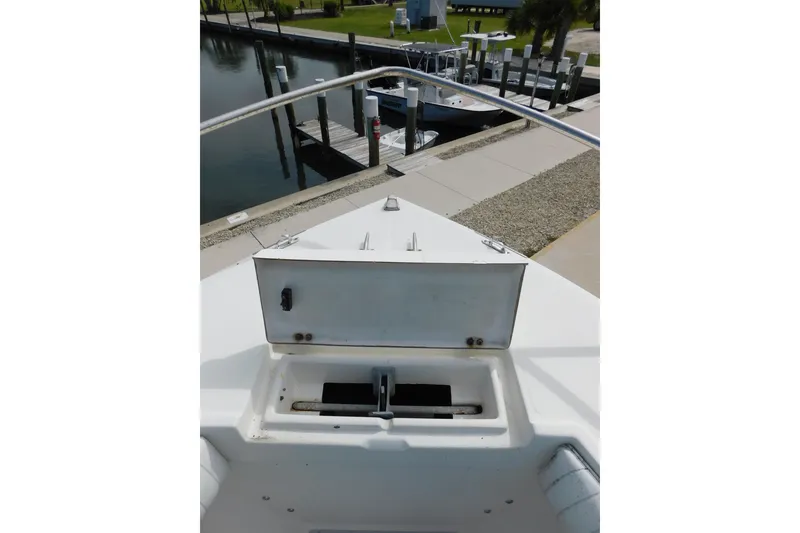 Slide: The Image of 1996 Regulator 23 Center Console boat bow with open storage compartment at dock. - 25