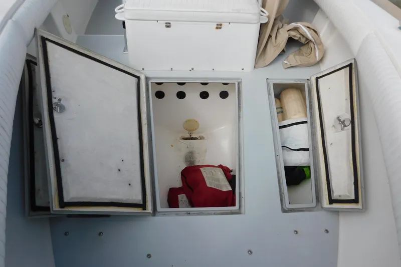 Slide: The Image of 1996 Regulator 23 Center Console boat storage compartments with open hatches and visible gear. - 31