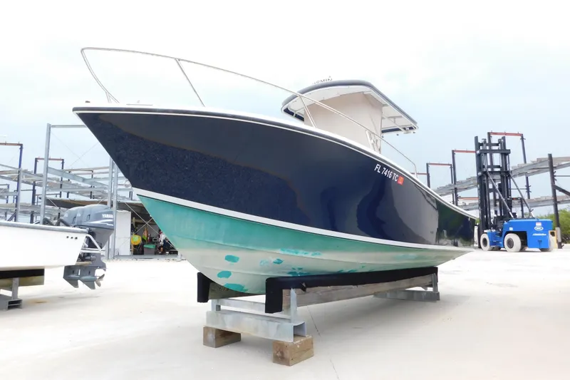 Slide: The Image of 1996 Regulator 23 Center Console boat on dry dock, blue and white hull. - 1