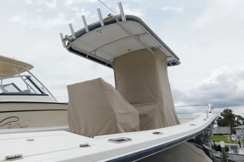 Slide: The Image of 1996 Regulator 23 Center Console boat with protective covers, docked under cloudy skies. - 11