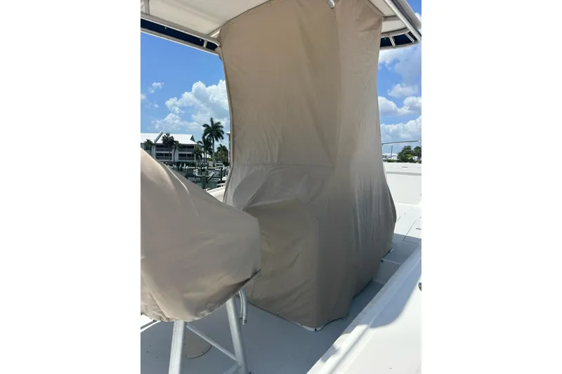 Slide: The Image of 1996 Regulator 23 Center Console boat with protective covers under a clear blue sky. - 12