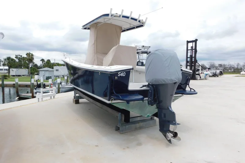 Slide: The Image of 1996 Regulator 23 Center Console boat with covered engine, docked on a concrete platform. - 5