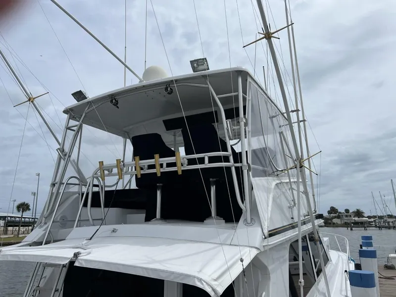 Slide: The Image of 1991 Viking Convertible yacht with upper deck and fishing rod holders at marina. - 6