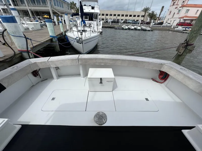 Slide: The Image of 1991 Viking Convertible boat deck at marina with docked sailboats in background. - 9