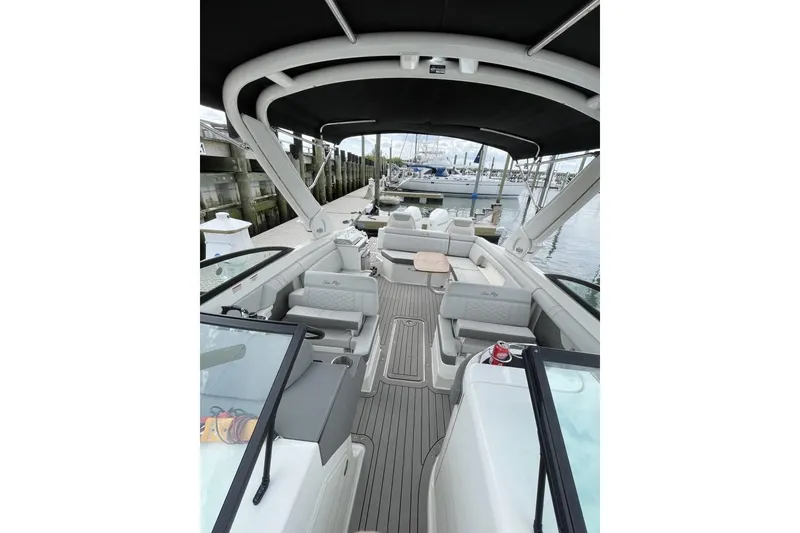 Slide: The Image of 2023 Sea Ray 290 Amberjack boat interior with seating and canopy at dock. - 11