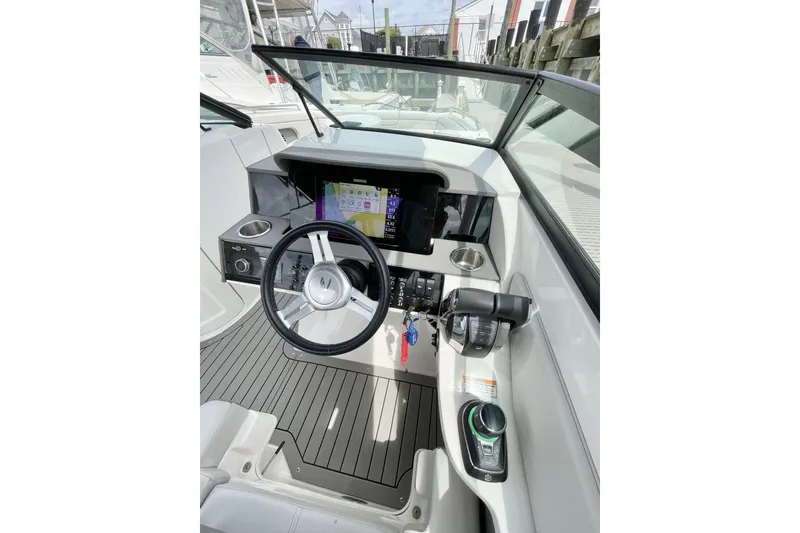 Slide: The Image of 2023 Sea Ray 290 Amberjack helm with steering wheel and navigation display. - 12