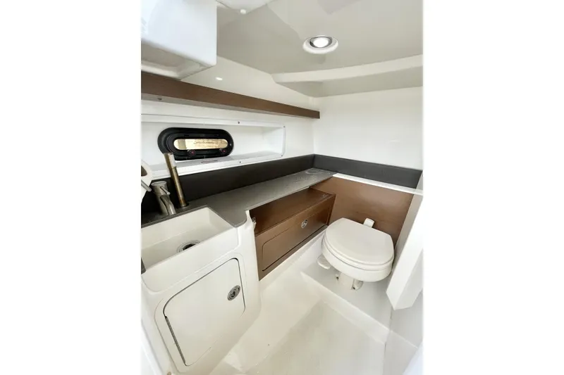 Slide: The Image of 2023 Sea Ray 290 Amberjack cabin interior with sink, toilet, and storage. - 14