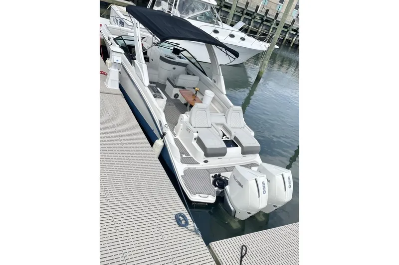 Slide: The Image of 2023 Sea Ray 290 Amberjack docked, featuring dual outboard engines and spacious seating. - 4