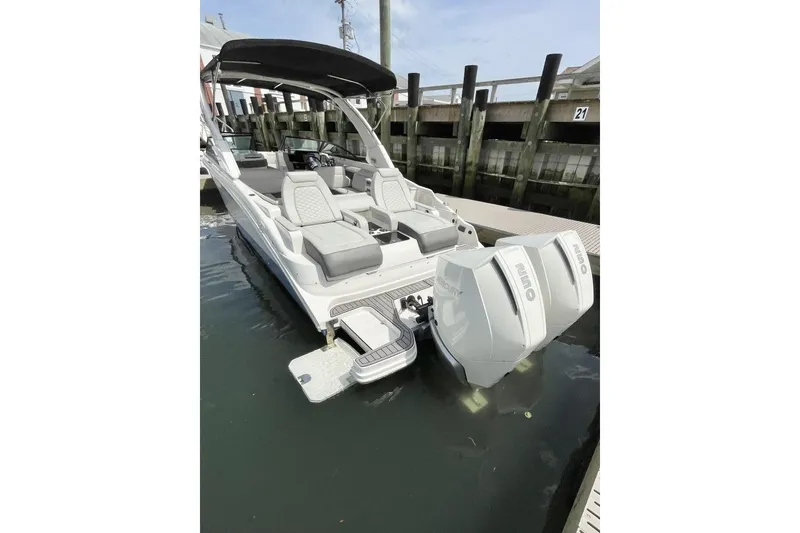 Slide: The Image of 2023 Sea Ray 290 Amberjack boat docked with dual outboard engines. - 5