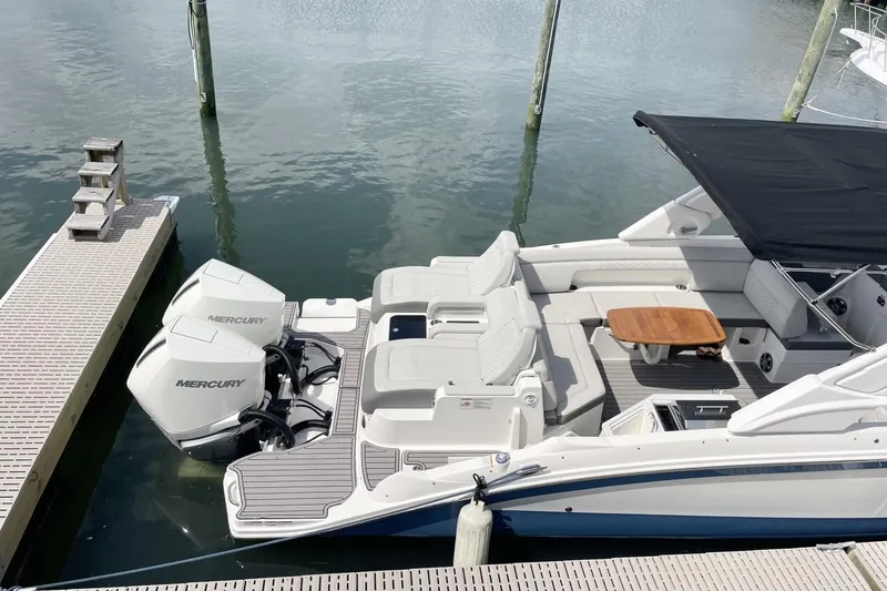 Slide: The Image of 2023 Sea Ray 290 Amberjack boat docked, featuring twin Mercury engines and spacious seating area. - 7