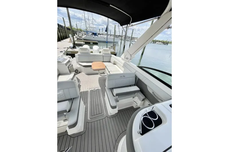 Slide: The Image of 2023 Sea Ray 290 Amberjack boat interior with seating and table at marina. - 9