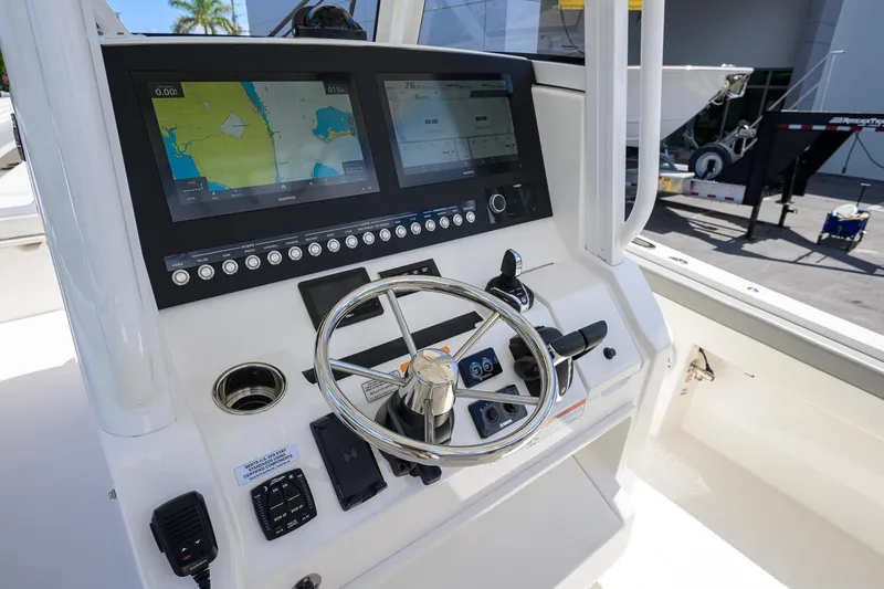 Slide: The Image of 2023 Regulator 28 boat dashboard with navigation screens and steering wheel. - 10