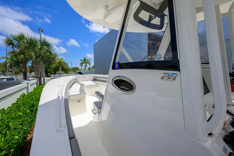 Slide: The Image of 2023 Regulator 28 boat with sleek design, docked under clear blue sky. - 11