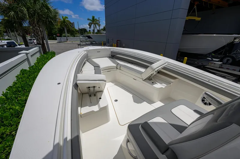 Slide: The Image of 2023 Regulator 28 boat interior with seating, docked outdoors under blue sky. - 13