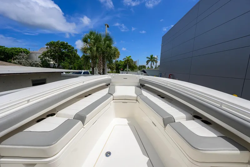 Slide: The Image of 2023 Regulator 28 boat interior with cushioned seating, under a clear blue sky. - 15
