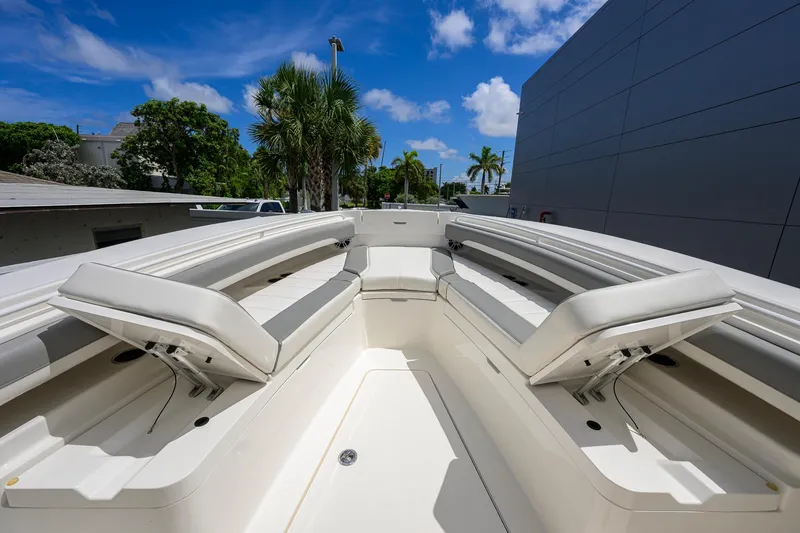 Slide: The Image of 2023 Regulator 28 boat interior with white seating, under a clear blue sky. - 16