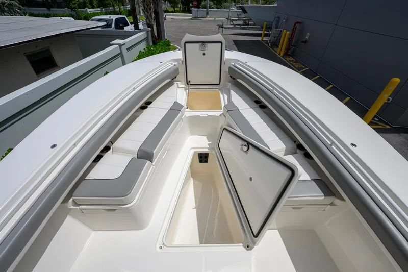 Slide: The Image of 2023 Regulator 28 boat interior with open storage compartments and cushioned seating. - 17